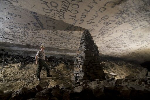 un esploratore intento a decifrare scritte misteriose sul soffitto di una caverna