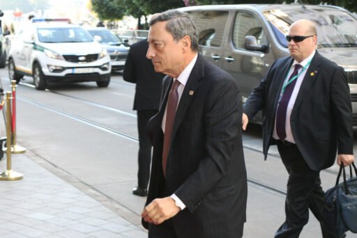 Mario Draghi, accompagnato dai suoi portaborse