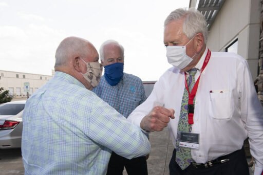 3 anziani con la mascherina si salutano dandosi il gomito