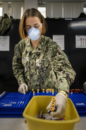 Una ragazza della marina militare analizza delle fiale