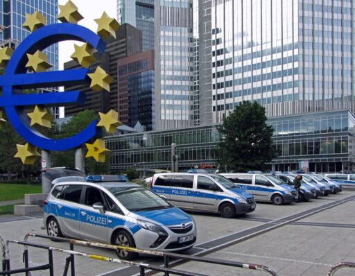 Macchine della polizia parcheggiate sotto il glifo dell'Euro