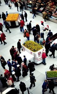 Una folla indaffarata, intenta a consumare presso i banchi di un mercato